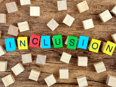 Wooden blocks spelling "INCLUSION"