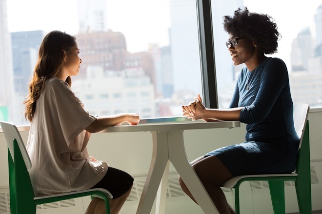 Two people in a consultation at a table.